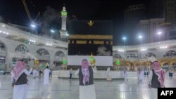 A handout photo provided by the Saudi Ministry of Media shows pilgrims burning incense as they walk around the Kaaba, Islam's holiest shrine, at the Grand Mosque, in Mecca, Saudi Arabia, July 26, 2020. 