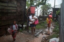 Personas cargan sus pertenencias mientras se dirigen a un refugio cuando el huracán Iota se acercaba a Puerto Cabezas, Nicaragua, 16 de noviembre de 2020.