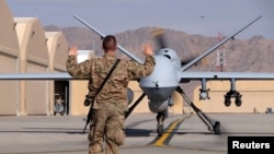 Serangan tentara AS memberikan instruksi kepada sebuah pesawat nirawak (drone) MQ-9 Reaper di pangkalan udara Kandahar, Afghanistan (foto: dok). 