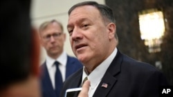 FILE - U.S. Secretary of State Mike Pompeo speaks to the media before departing from al-Bateen Air Base in Abu Dhabi, United Arab Emirates, Sept. 19, 2019, as U.S. special representative on Iran Brian Hook, left, listens. 