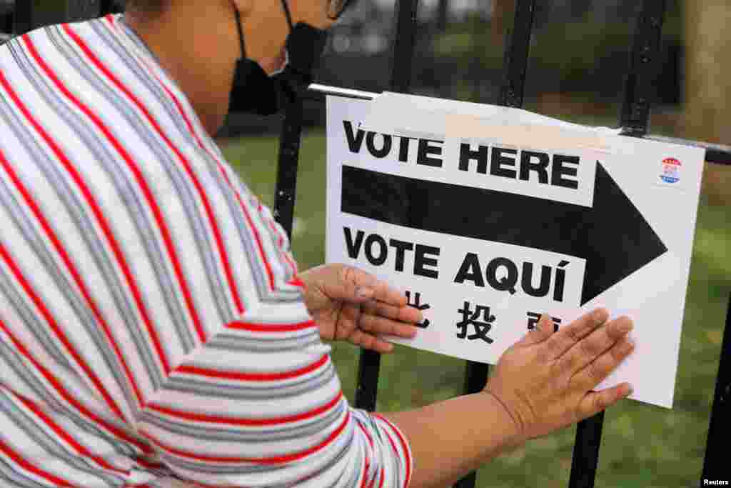 Un trabajador electoral coloca carteles fuera de un centro de votación en el Centro Comunitario James Weldon Johnson en Harlem, en la ciudad de Nueva York, Nueva York, 3 de noviembre de 2020.