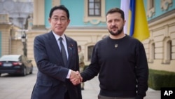 El primer ministro japonés, Fumio Kishida, (izq) y el presidente ucraniano Volodymyr Zelenskyy (der), se estrechan las manos durante una visita de Kishida a Kiev el 21 de marzo de 2023.