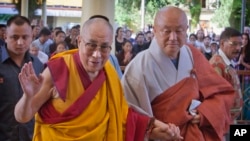 2015年9月7日，西藏精神领袖达赖喇嘛（左）抵达印度达兰萨拉（Dharmsala）的楚拉康寺（Tsuglakhang），向信众挥手致意。