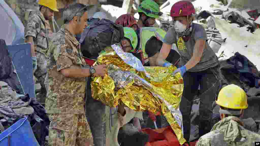Le corps d'une victime sorti des ruines après le séisme à Amatrice, Italie, le 24 août 2016.