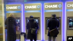 FILE - Customers uses ATM's at at a branch of Chase Bank.