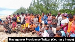 Des enquêteurs échangent avec des habitants sur les rives après un accident de bateau qui a fait des dizaines de morts à Soanierana Ivongo, dans le nord de Madagascar, le 20 décembre 2021. 