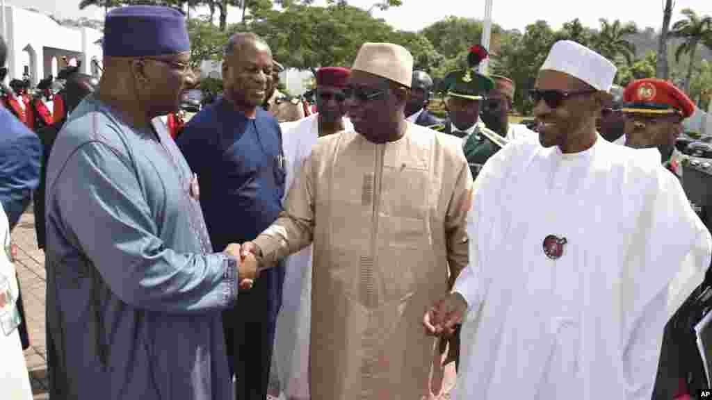 Le ministre nigérian de l'Intérieur, Abdulrahman Danbazau, souhaite la bienvenue au président sénégalais Macky Sall, et au président nigérian Muhammadu Buhari, juste avant une réunion à Abuja, le 9 janvier 2017.