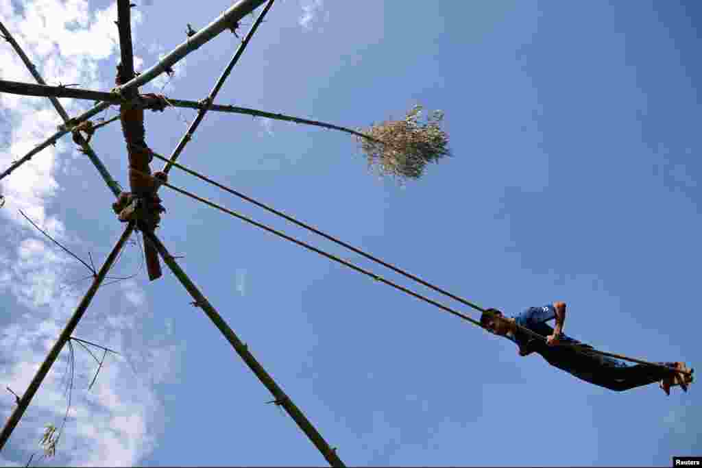 A man plays on a swing made from bamboo during Dashain, the country's biggest religious Hindu festival, in Kathmandu, Nepal.
