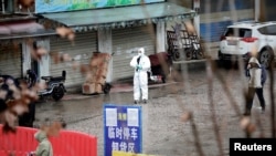 一名身著防護服的工作人員在被關閉的武漢海鮮市場內。（2020年1月10日）