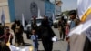 Seorang perempuan Afghanistan bersama anaknya berjalan di antara para pendukung Taliban di jalan Kota Kabul, Afghanistan, di dekat Kedutaan Besar AS pada 15 Agustus 2023. (Foto: Reuters/Ali Khara)
