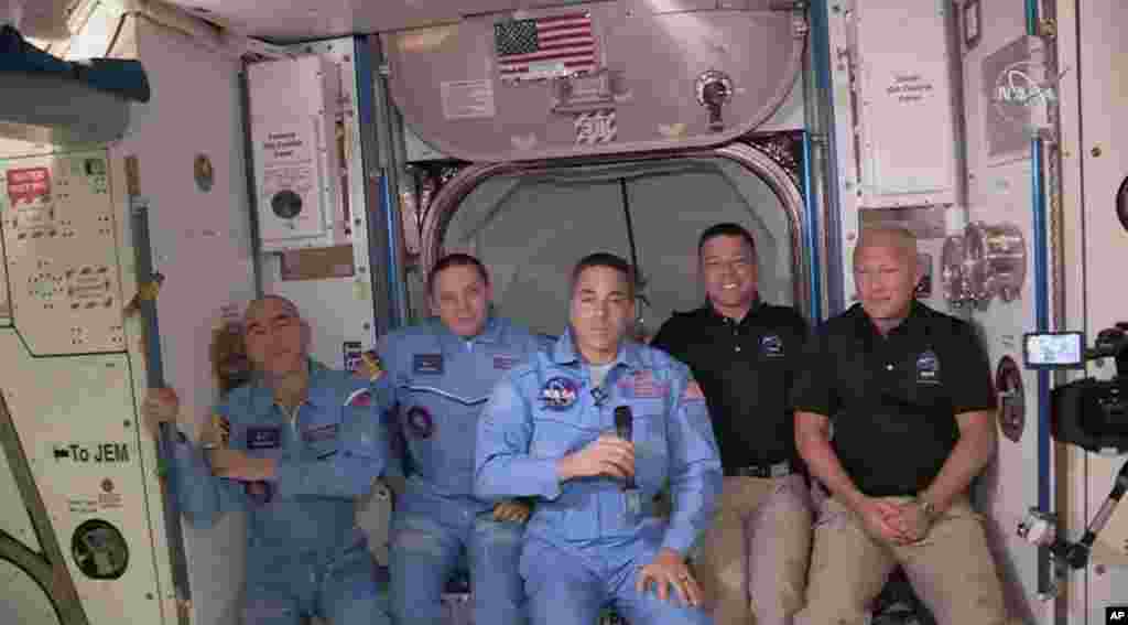 Esta foto proporcionada por la NASA muestra a Bob Behnken y Doug Hurley, a la derecha, uniéndose a la tripulación en la Estación Espacial Internacional.