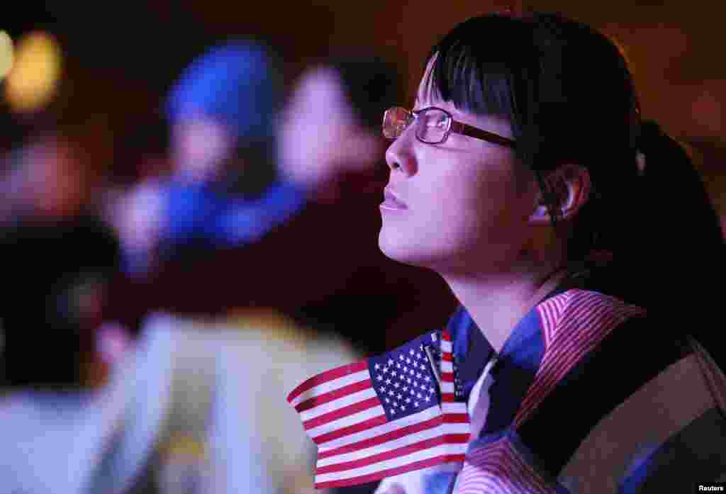 Kim Li, a junior at Denver University, watches the first 2012 U.S. presidential debate between President Barack Obama and Republican presidential nominee Mitt Romney on an outdoor screen at Denver University in Denver, Colorado, October 3, 2012.