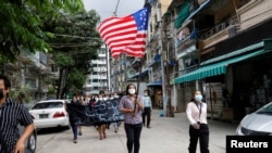 Warga berpawai dengan bendera Pemerintah Persatuan Nasional (NUG) pemerintah bayangan Myanmar yang dibentuk antara lain oleh anggota parlemen yang digulingkan, di Yangon, Myanmar, Minggu, 18 April 2021. 