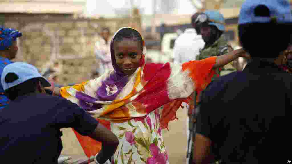 Une femme passe par un contrôle de sécurité avant d'entrer dans un bureau de vote pour le second tour de l'élection présidentielle couplée aux législatives dans le quartier PK5 de Bangui, en République centrafricaine, 14 février 2016.