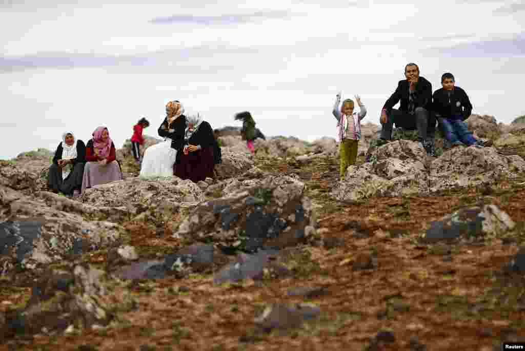 Turkish Kurds watch the Syrian town of Kobani from near the Mursitpinar border crossing, on the Turkish-Syrian border in the southeastern town of Suruc, Oct. 19, 2014.