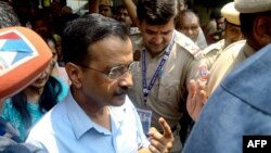 Arvind Kejriwal (kiri), Menteri Utama New Delhi sekaligus tokoh oposisi India, menunjukkan jarinya setelah menggunakan hak pilihnya dalam pemilu India di sebuah TPS di New Delhi pada 25 Mei 2024. (Foto: AFP)
