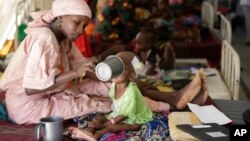 In this 2016 photo, a mother feeds her malnourished child at a feeding center run by Doctors Without Borders in Maiduguri, Nigeria. Officials blame famine-like conditions on Boko Haram militants. ( AP Photo/Sunday Alamba)