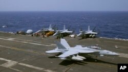 A U.S. Navy F-18 fighter jet lands on the deck of the USS Carl Vinson (CVN 70) aircraft carrier following a routine patrol off the disputed South China Sea, March 3, 2017. 