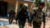 FILE - LT Saw Kaw, seorang prajurit Tentara Pembebasan Nasional Karen (KNLA), berjalan bersama anggota timnya setelah memeriksa rumah seorang pejabat tinggi militer Myanmar di Batalyon Infanteri 275 di Myawaddy, 15 April 2024.