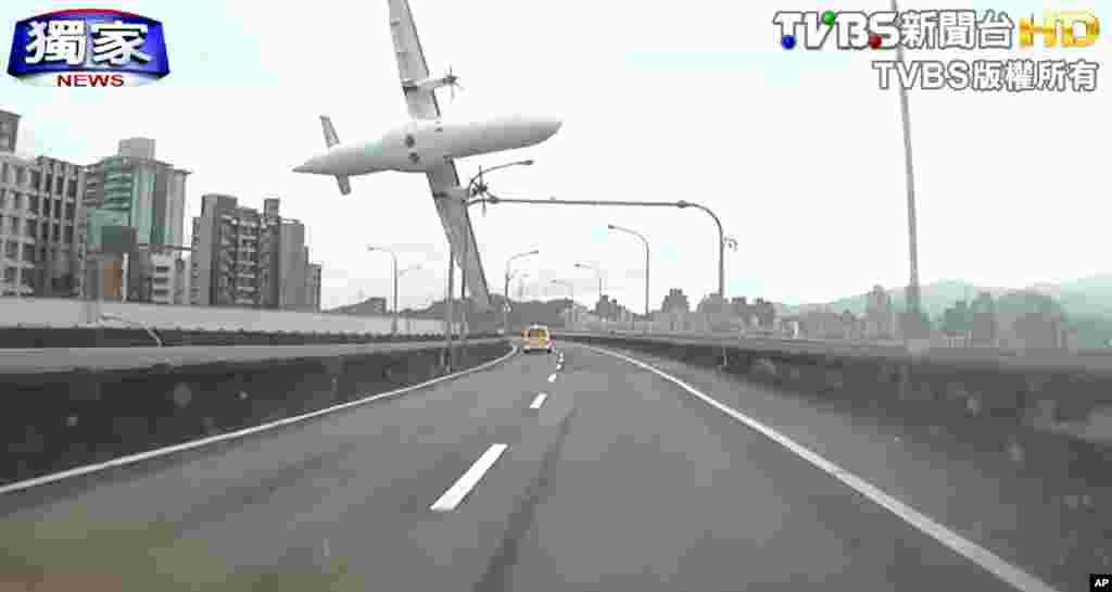 This image taken from video provided by TVBS shows a commercial airplane moments before it clipped an elevated roadway and careened into a river in Taipei, Taiwan, Feb. 4, 2015.