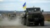 A Ukrainian military convoy moves ahead on the road near the eastern Ukrainian town of Slovyansk, Oct. 5, 2014. 