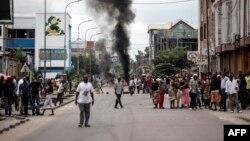 Des protestants reçoivent des gaz lacrymogènes sur eux lors des marches contre Kabila à Kinshasa, le 21 janvier 2018.