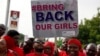 FILE - Nigerians carry a sign calling on the government to rescue the kidnapped girls during a demontration in Abuja.