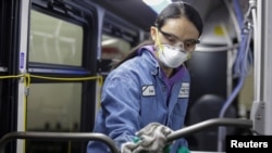 Una trabajadora de mantenimiento desinfecta el interior de un autobús de transporte público en Seattle, EE.UU.