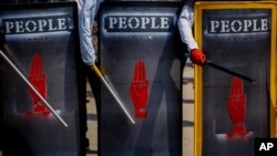 Demonstran antikudeta memegang perisai darurat selama protes di Yangon, Myanmar, 9 Maret 2021. (Foto: AP)