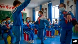 FILE - Schoolchildren dance during a music class at a primary school in Kashgar in China's Xinjiang Uyghur Autonomous Region, April 19, 2021. At the United Nations this week, 43 countries expressed in a formal statement their concerns about China's treatment of Uyghurs.