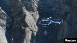 Helikopter penyelamat Perancis mencari puing-puing pesawat Airbus A320 di lokasi jatuhnya, dekat Seyne-les-Alpes, Pegunungan Alpen (27/3). (Reuters/Gonzalo Fuentes)