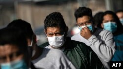 Inmigrantes mexicanos cruzan el puerto de entrada de Matamoros, en México, tras ser deportados por el Gobierno de EE. UU., el 24 de febrero de 2021.