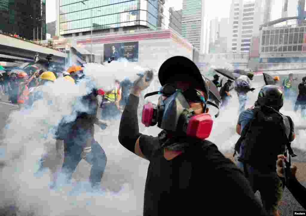 一名香港反送中抗议者在政府总部附近把警察射出的催泪弹扔回警察。(2019年9月15日)