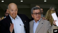 ARCHIVO - José Otty Patiño, jefe negociador del gobierno colombiano, a la izquierda, y Pablo Beltrán, comandante y jefe negociador del Ejército de Liberación Nacional saludan, tras el acto de apertura de la segunda ronda de diálogos en Ciudad de México, en febrero de 2023. 