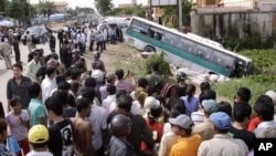 FILE: Crowds of people watch a bus collided with a motorcycle on the outskirts of Phnom Penh, Cambodia, Sept. 24, 2009. 