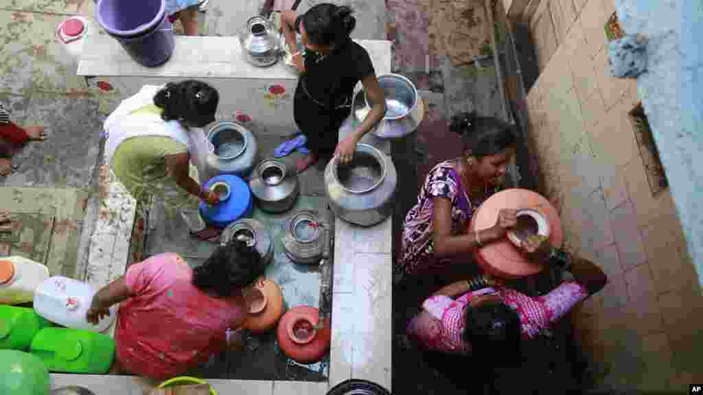 Un groupe de femmes recueillent de l'eau d'un robinet dans un bidonville à Mumbai, en Inde, le 22 mars 2017.