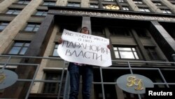 Rossiyadagi nodavlat tashkilotlarga qarshi siyosatdan norozi namoyishchi, Moskva, 6-iyul 2012-yil.