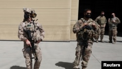 FILE - U.S. troops stand guard during a handover ceremony of A-29 Super Tucano planes from U.S. to the Afghan forces, in Kabul, Sept. 17, 2020. 