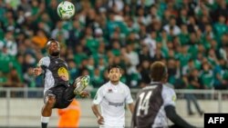 Le milieu de terrain de Mazembe Miche Mika (à g.) dégage le ballon lors du match aller des quarts de finale de la Ligue des champions de la CAF entre le Raja Casablanca du Maroc et le Mazembe du Congo au stade Mohammed V de Casablanca, le 28 février 2020. (Photo by STR / AFP)