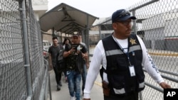 A security guard leads a group of U.S. asylum seekers out of Mexican immigration offices after they were returned by U.S. authorities to wait in Mexico under the so-called Remain in Mexico program, in Ciudad Juarez, Mexico, July 17, 2019.