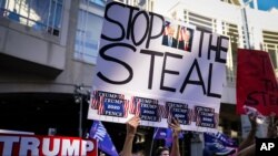 Partidarios del presidente Donald Trump se reúnen con carteles donde se lee: "Pare el robo", el alusión a supuesto fraude en conteo de votos, en el Centro de Convenciones de Filadelfia, el viernes 6 de noviembre de 2020..