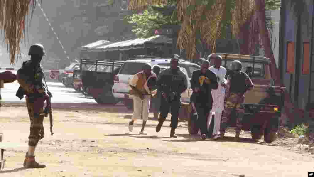 Mutane su na gudu daga hotel din Radisson Blu Hotel na Bamako, Mali, Jumma'a, Nov. 20, 2015.