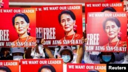 Manifestantes portan carteles con la efigie de la exlíder de facto de Myanmar Aung San Suu Kyi en una protesta en Naypyitaw, el 15 de febrero de 2021.