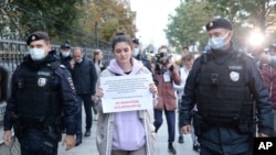 Архивное фото. Сотрудники полиции задерживают Алесю Мароховскую из издания «Военные истории» у здания Министерства юстиции России. На плакате написано: «Нет иностранных агентов, есть журналисты». Москва, 8 сентября 2021 года.
