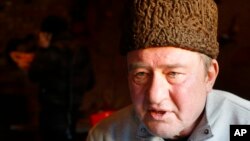 FILE - In this photo taken on Monday, Jan. 25, 2016, a Crimean Tatar leader, Ilmi Umerov, speaks during an interview with the Associated Press in Simferopol, Crimea. 