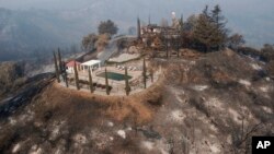 Los bomberos trabajan durante el fin de semana para proteger el centro turístico de Lake Elsinore y otras comunidades a medida que el fuego se propaga. 