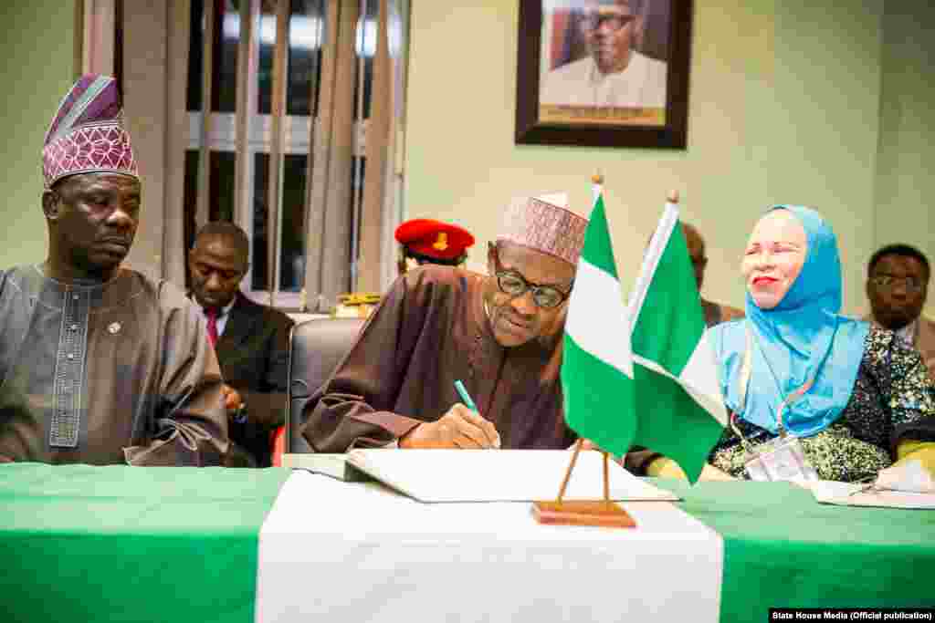 Shugaba Muhammadu Buhari yana bude Cibiyar Ayyukan Shige da Ficen Baki ta Najeriya tare da karamar jakadiya Mrs Uche Ajulu-Okeke da mai rikon mukamin babban jakadan Najeriya a Afirka ta Kudu, Mr. Martins Cobham a lokacin da ya gana da al'ummar Najeriya a karamin ofishin jakadancin Najeriya na Johannesburg a Afirka ta Kudu.
