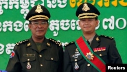 រូបឯកសារ៖ លោកនាយករដ្ឋមន្ត្រី ហ៊ុន សែន (ឆ្វេង) ថតរូបជាមួយនឹងកូនប្រុសច្បងរបស់លោក គឺលោក ហ៊ុន ម៉ាណែត នៅជាយរាជធានីភ្នំពេញ ថ្ងៃទី១៣ ខែតុលា ឆ្នាំ២០០៩។ (REUTERS/Chor Sokunthea/File Photo)