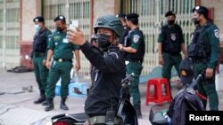 Cambodian policemen are seen at a checkpoint during lockdown to prevent the coronavirus disease (COVID-19) spread in Phnom Penh, Cambodia, April 21, 2021. REUTERS/Cindy Liu