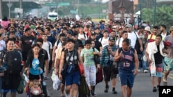 Migrants walk along the highway through Suchiate, Chiapas state in southern Mexico, July 21, 2024, during their journey north toward the U.S. border.